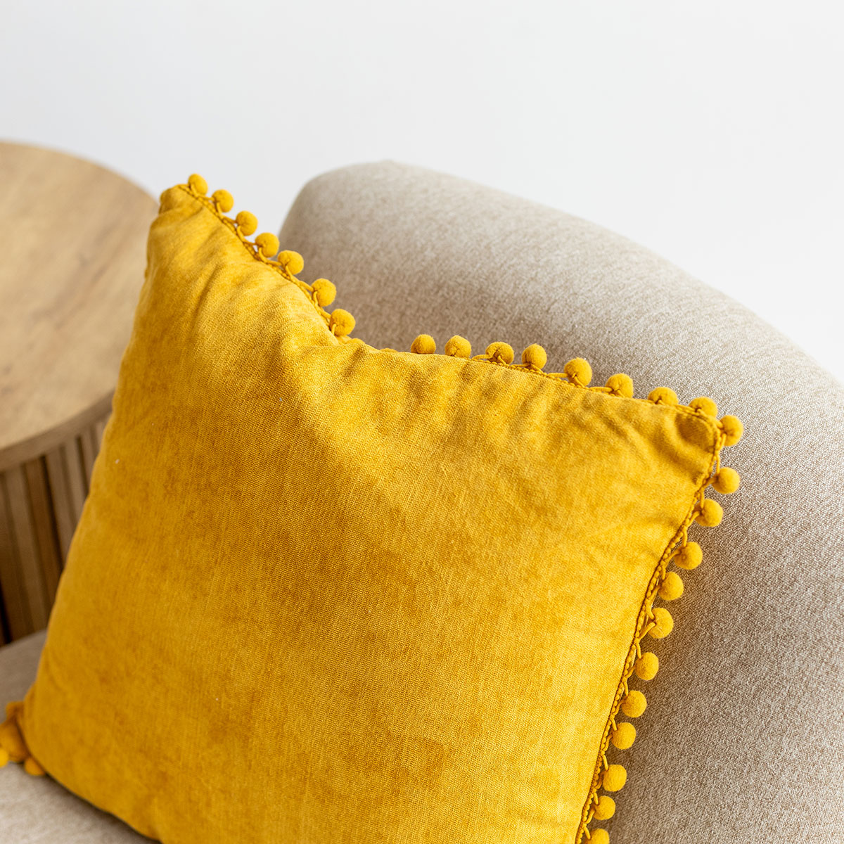 Almofada ocre com pompons 40x40cm