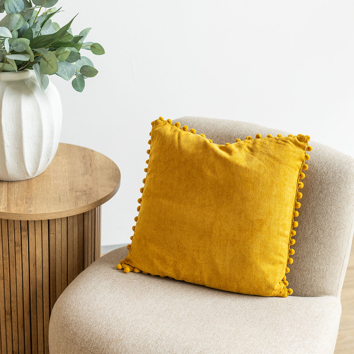 Almofada ocre com pompons 40x40cm