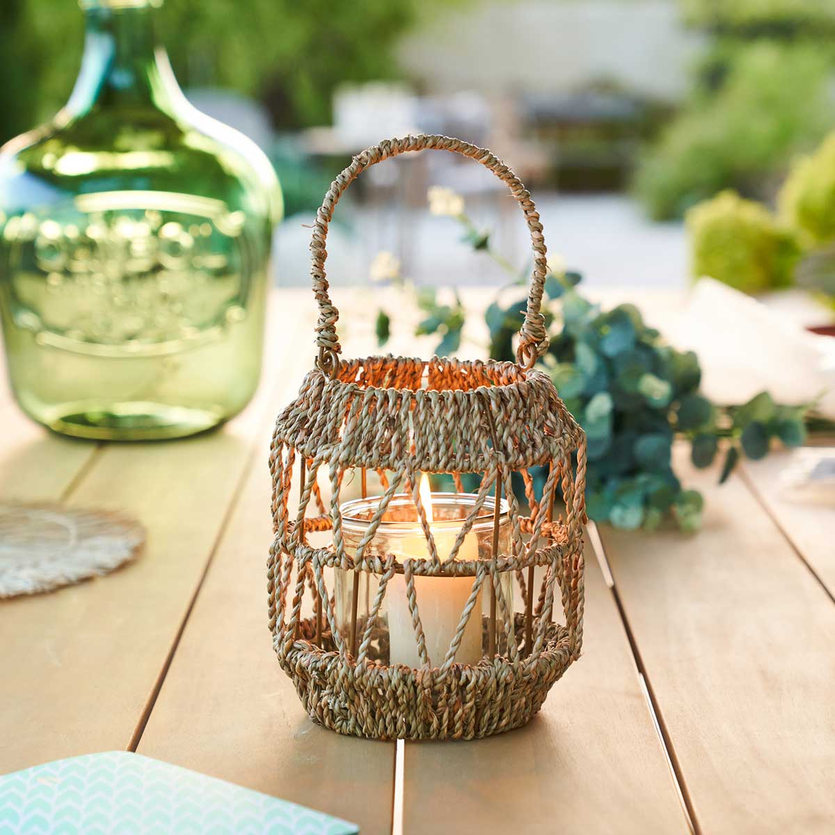 Lanterna em rattan bege com castiçal de vidro